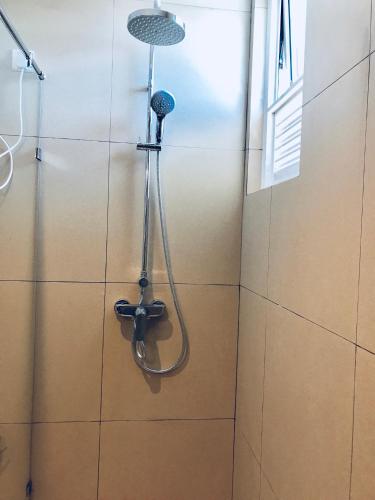 a shower in a bathroom with a shower head at Araliya OceanFront Condos Nilaveli, Trincomalee in Nilaveli