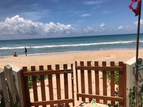 a wooden fence on a beach with the ocean at Araliya OceanFront Condos Nilaveli, Trincomalee in Nilaveli