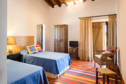 カンポ・マイオルにあるMonte Alto Agroturismoのベッドルーム1室(ベッド2台、椅子、テレビ付)