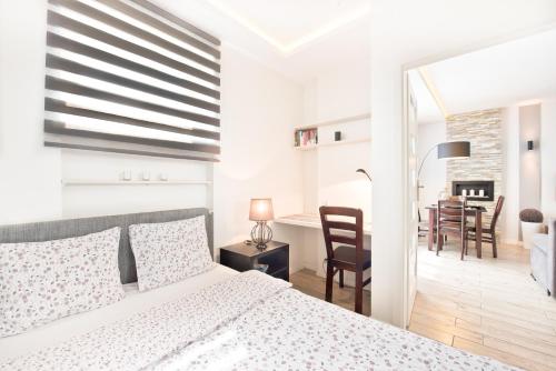- une chambre blanche avec un lit et une salle à manger dans l'établissement Nice Stay Apartment, à Toruń