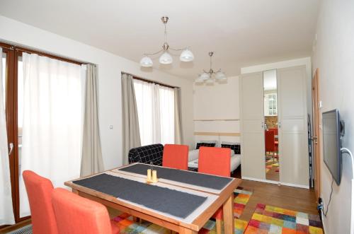 een woonkamer met een eettafel en rode stoelen bij Apartman Mozartova in Praag