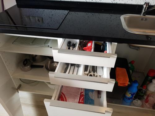 a kitchen cabinet with white drawers and a sink at Apartamentos Villajovita in Ceuta