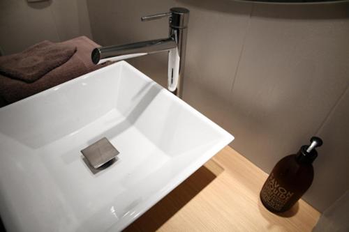 a white sink in a bathroom with a soap dispenser at Atout Carmes in Toulouse