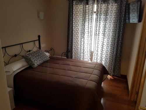 a bedroom with a large bed and a window at Hostal Arenal in San Vicente de la Barquera