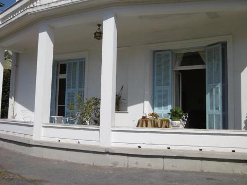 a white house with a window and a table at Hotel Villa Maria in Sanremo