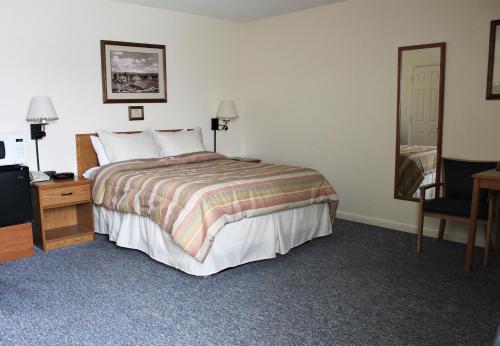 a bedroom with a bed and a dresser and a mirror at Mill Inn in Sheridan