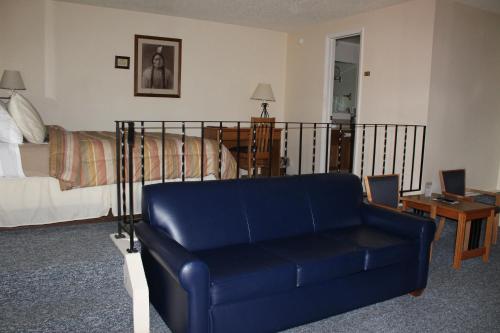 a living room with a blue couch and a bed at Mill Inn in Sheridan