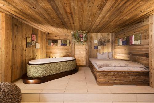 a large bathroom with a tub and a bed at Living & Spa Vitalhotel Edelweiss in Neustift im Stubaital