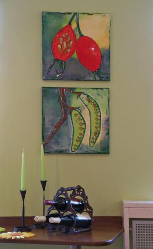 a table with glasses and two paintings on the wall at Hotel Haus am Berg in Trier