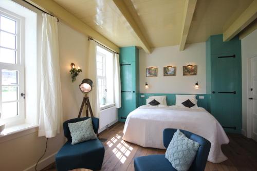 - une chambre avec un lit et deux chaises bleues dans l'établissement B&B Lhee-Gaarde, à Dwingeloo