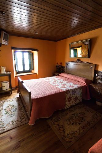 a bedroom with a bed with a red bedspread at Paraíso Ortegal in Feás