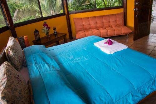 a blue bed in a room with a couch at Hotel Vista de Olas in Santa Teresa Beach