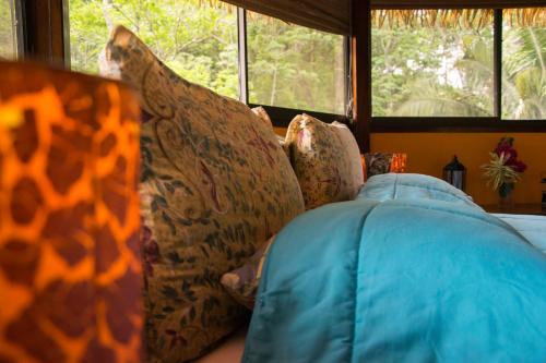 a couch with pillows on it in a room with windows at Hotel Vista de Olas in Santa Teresa Beach