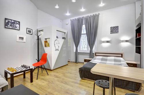 a bedroom with a bed and a table and chairs at Apartments Logic Hall in Saint Petersburg