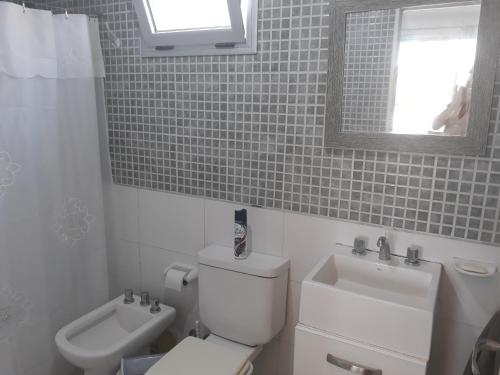a bathroom with a toilet and a sink and a mirror at Departamento En Tigre in Tigre