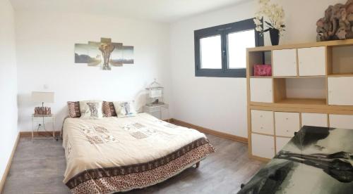 um quarto branco com uma cama e uma janela em Gîte Chez EVA em Le Buisson de Cadouin