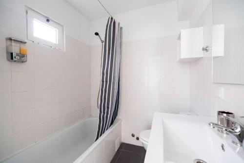 baño con cortina de ducha en blanco y negro en Olá Lisbon - Rato Terrace IV en Lisboa