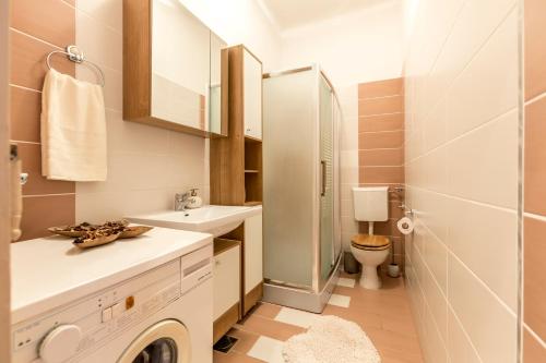 ein Badezimmer mit einem Waschbecken und einer Waschmaschine in der Unterkunft Boban Sunny Apartment in Solin