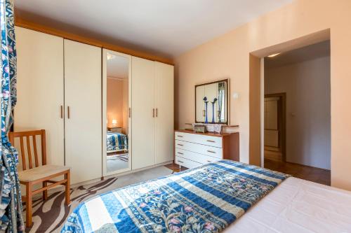 1 dormitorio con cama, tocador y espejo en Boban Sunny Apartment en Solin