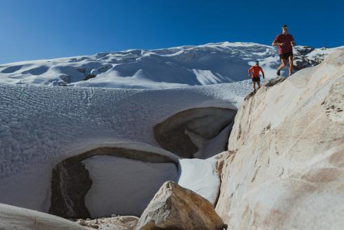 two people walking on a snow covered mountain at Caroline lodging in Huaraz