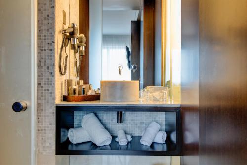 a bathroom with a sink and a shelf with towels at VIP Grand Lisboa Hotel & Spa in Lisbon