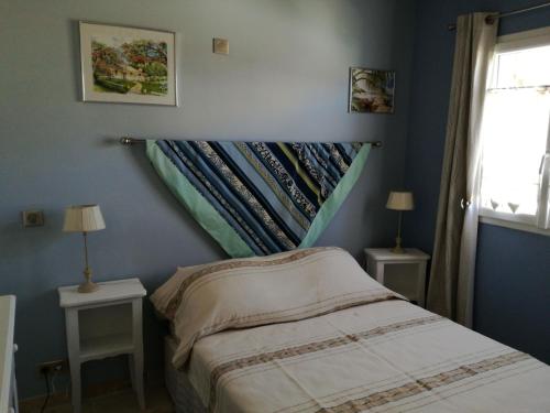 フォルカルキエにあるGite Les Trois Oliviersのベッドルーム1室(ベッド1台、ランプ付きテーブル2台付)