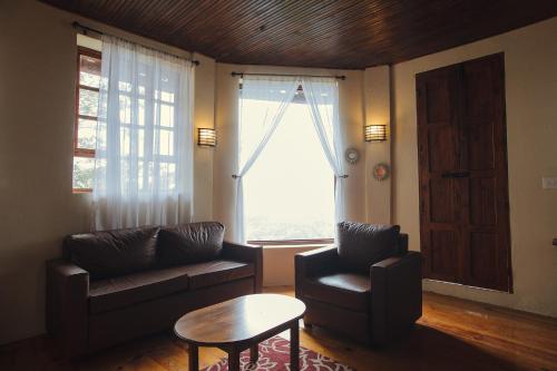 a living room with a couch and a table and a window at Hotel Montecillos in San José