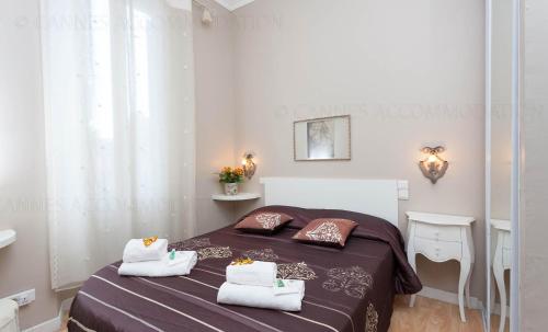 une chambre avec un lit avec des serviettes dessus dans l'établissement Feliz, à Cannes