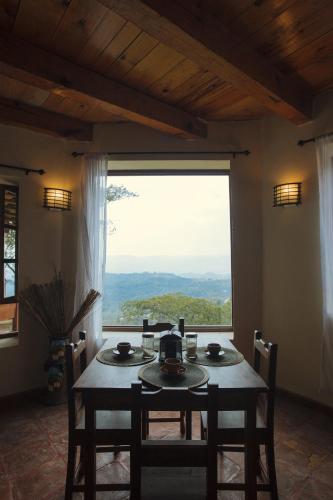 a dining room with a table and a large window at Hotel Montecillos in San José