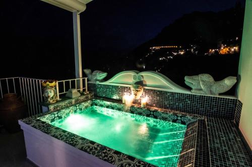 basen z oświetleniem na balkonie w nocy w obiekcie Villa Pietra Santa w mieście Positano