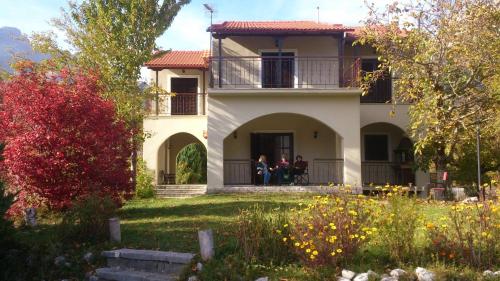 two people sitting on the porch of a house at Ξενώνας Αλώνι-Guesthouse Aloni in Theodoriana