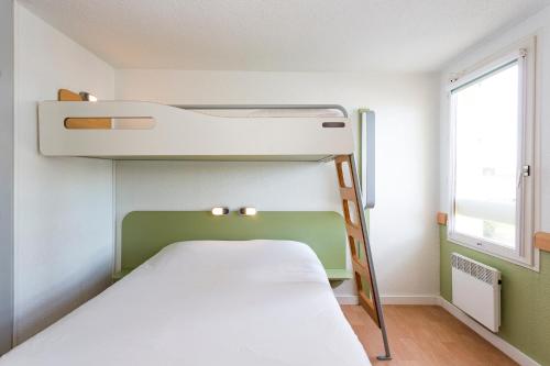 a bunk bed in a small room with a window at ibis budget Quimper in Quimper