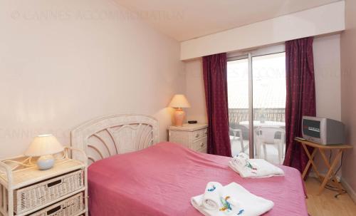 - une chambre avec un lit rose et une fenêtre dans l'établissement Lemoine, à Cannes