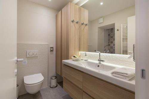 a bathroom with a sink and a toilet and a mirror at Classy Design Accommodation in Zadar