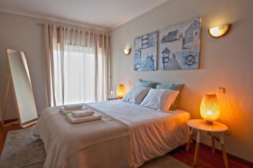 una camera da letto con un letto grande con due lampade di Cozy Beach Front with Rooftop a Vila do Conde