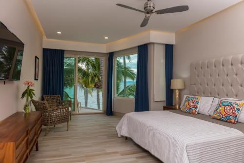 a bedroom with a bed and a desk and windows at Vista Vallarta All Suites On The Beach in Bucerías