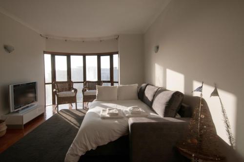 a living room with a couch and a television at Cozy Beach Front with Rooftop in Vila do Conde