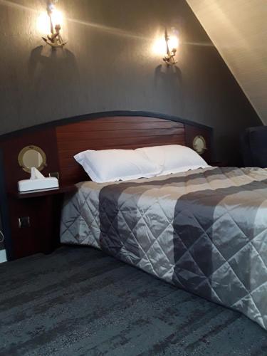 a bedroom with a bed with two lights on the wall at Les Ondines in Saint-Guénolé