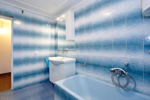 a blue tiled bathroom with a toilet and a sink at Apartmani Mlinar in Gornji Karin