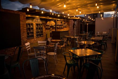 a restaurant with tables and chairs and lights at Hotel Real Azteca Boulevard in León