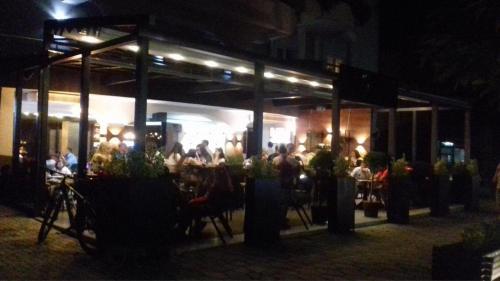 a group of people sitting at a restaurant at night at Septemvri 7 in Kavadarci