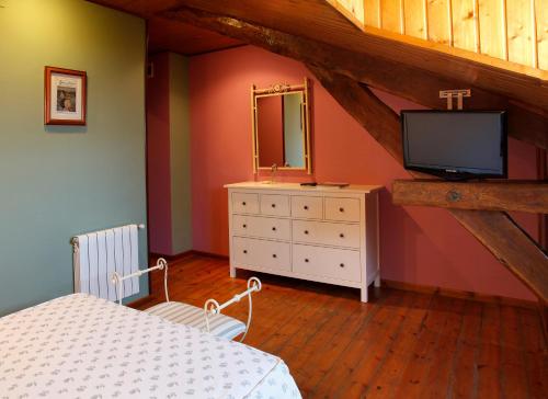 a bedroom with a bed and a television in a attic at Hotel Villa de Luarca in Luarca