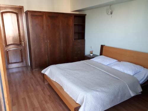 a bedroom with a large bed and a wooden cabinet at Apartment Archil Batumi in Batumi
