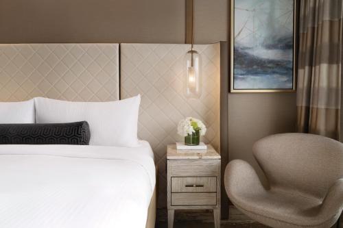 a hotel room with a bed and a chair at Fairmont Vancouver Airport In-Terminal Hotel in Richmond