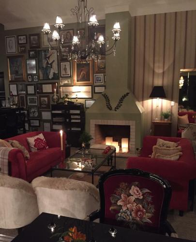 a living room with red couches and a fireplace at Casa Regaleira Hotel Boutique in Campos do Jordão