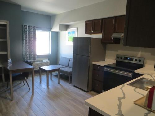 a small kitchen with a refrigerator and a table at Hotel Blue - Woodlands in Spring