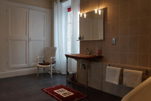 uma casa de banho com um lavatório e um espelho em Chateau de Savennes - Caveau de sabrage em Savennes