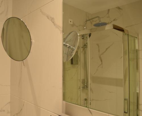a bathroom with a glass shower with a mirror at Alexakis Hotel & Spa in Loutra Ipatis