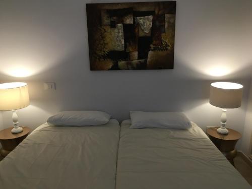 ラスパルマス・デ・グランカナリアにあるBeach line apartmentのランプ2つ付きの部屋のベッド2台