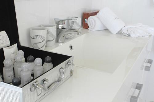 a bathroom counter with a sink and toiletries at Hotel Dom Aktera in Odesa